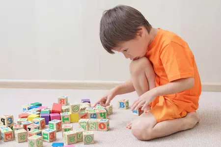 enfant jouant avec des cubes de bois