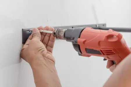 perceuse entrain de fixer dans un mur